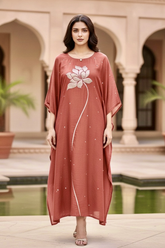 Woman wearing a long, flowing dress with a floral design in an outdoor setting. Product by Umaid Couture