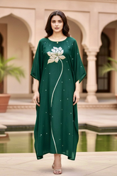 Woman wearing a green dress with floral design in an outdoor setting. Product by Umaid Couture