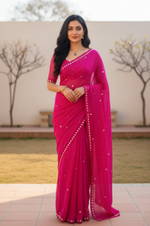 Woman wearing a bright pink lehriya saree by Umaid Couture with a silver Gota border outdoors.
