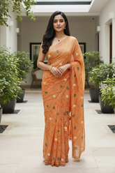 Woman in an Bandhej saree by Umaid Couture standing in a well-lit indoor setting with plants.