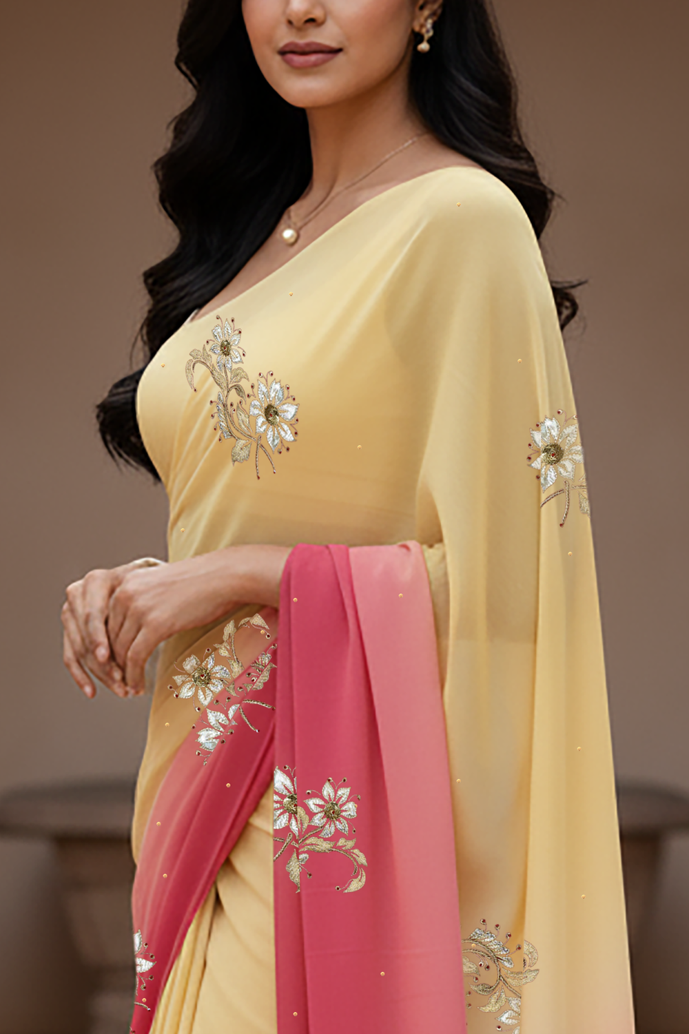 Woman wearing a yellow and pink saree by Umaid Couture with floral patterns indoors.