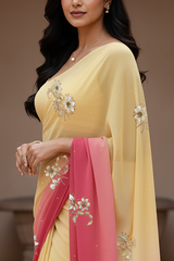 Woman wearing a yellow and pink saree by Umaid Couture with floral patterns indoors.