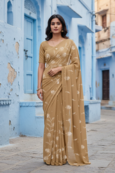 Woman in a beige saree standing in front of an architectural background. Product by Umaid Couture.