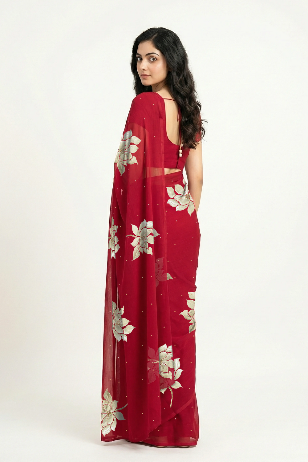 An Indian woman in Red Padma Saree embellished with Blooming lotus flowers made of Gota, Zari & sequins by craft of Aari-Zardosi, a product of Umaid Couture