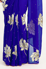 An Indian woman in blue Padma Saree embellished with Blooming lotus flowers made of Gota, Zari & sequins by craft of Aari-Zardosi, a product of Umaid Couture
