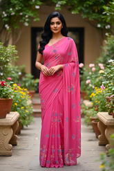 An Indian woman standing in a garden courtyard wearing a fuchsia pink chiffon saree embellished with blue and sliver sequin of lavender flower motifs by Umaid Couture.