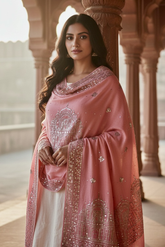 Woman wearing a traditional pastel pink hand embroidered pashmina shawl in with sequins temple motifs standing in a corridor