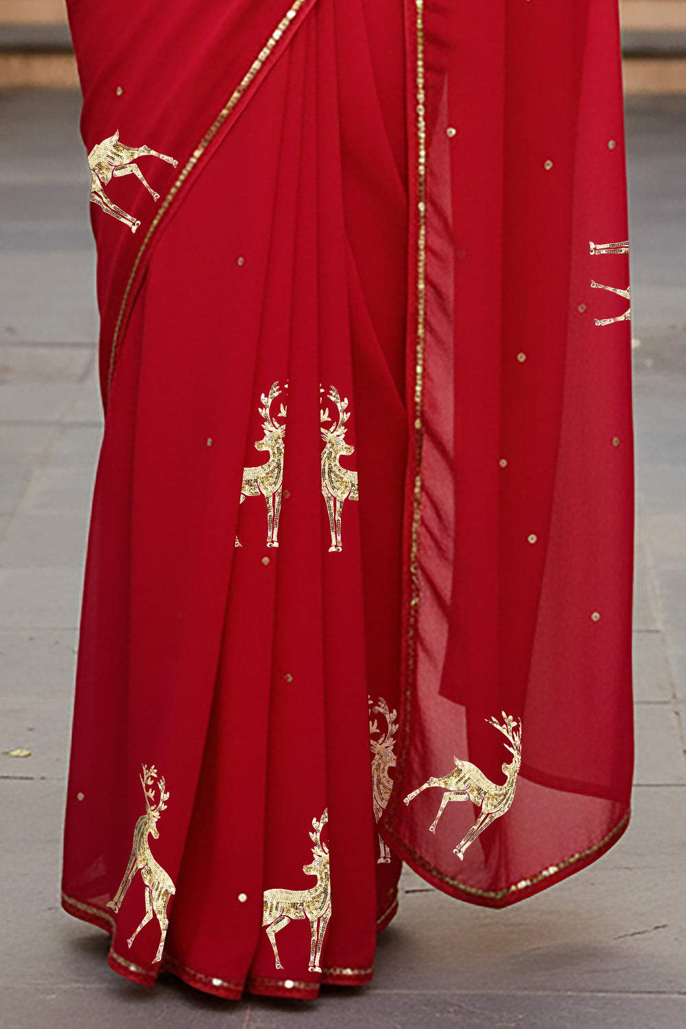 Red saree with gold deer embroidery on a wooden floor