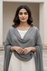 Woman wearing a gray scarf over a white top with a neutral background. product by Umaid Couture