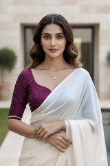 Woman wearing a light pink blouse and white saree with a blurred background. product by Umaid Couture