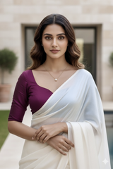 Woman wearing a light pink blouse and white saree with a blurred background. product by Umaid Couture