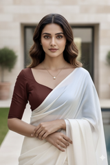Woman wearing a light pink blouse and white saree with a blurred background. product by Umaid Couture