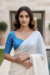 Woman wearing a white saree with a blue blouse in an outdoor setting. product by Umaid Couture