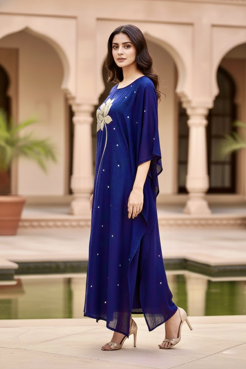 Woman wearing a blue dress with floral design in an outdoor setting. Product by Umaid Couture