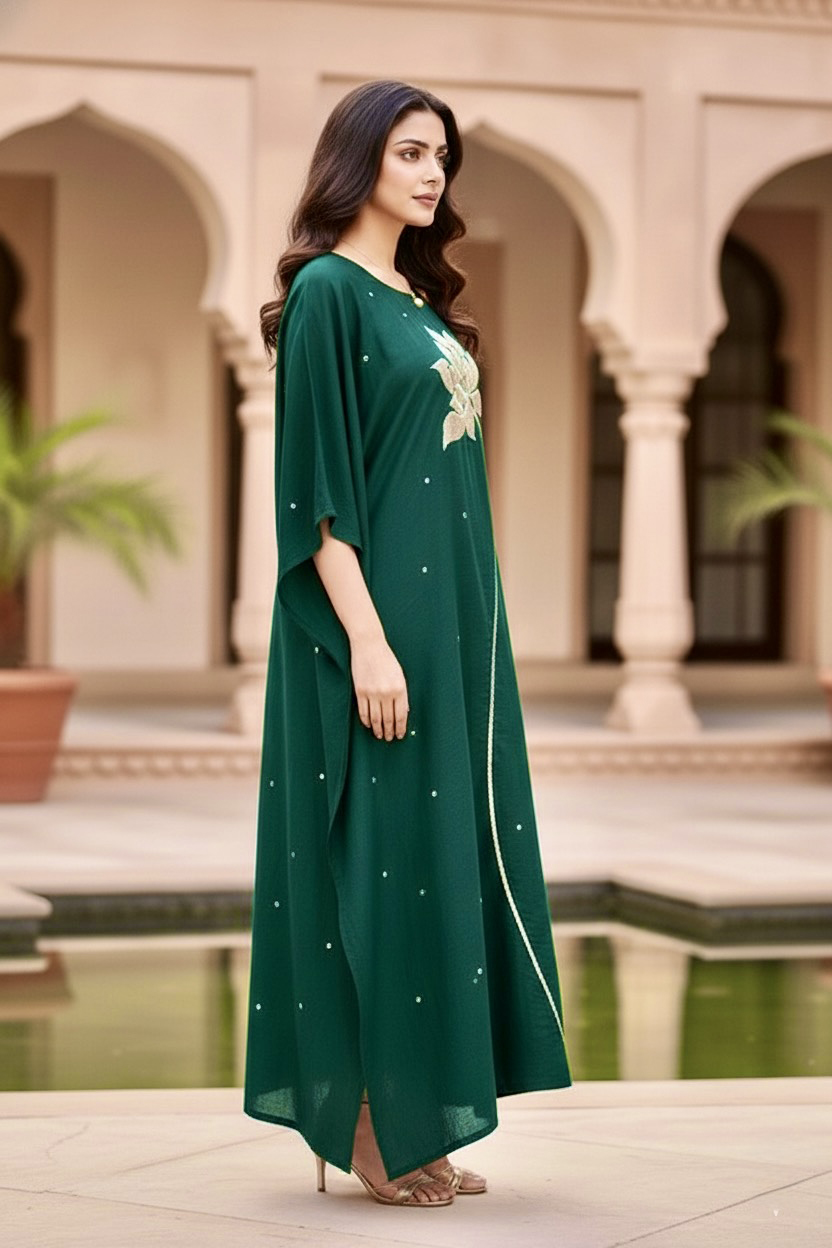 Woman in a green dress standing in front of an architectural background. Product by Umaid Couture