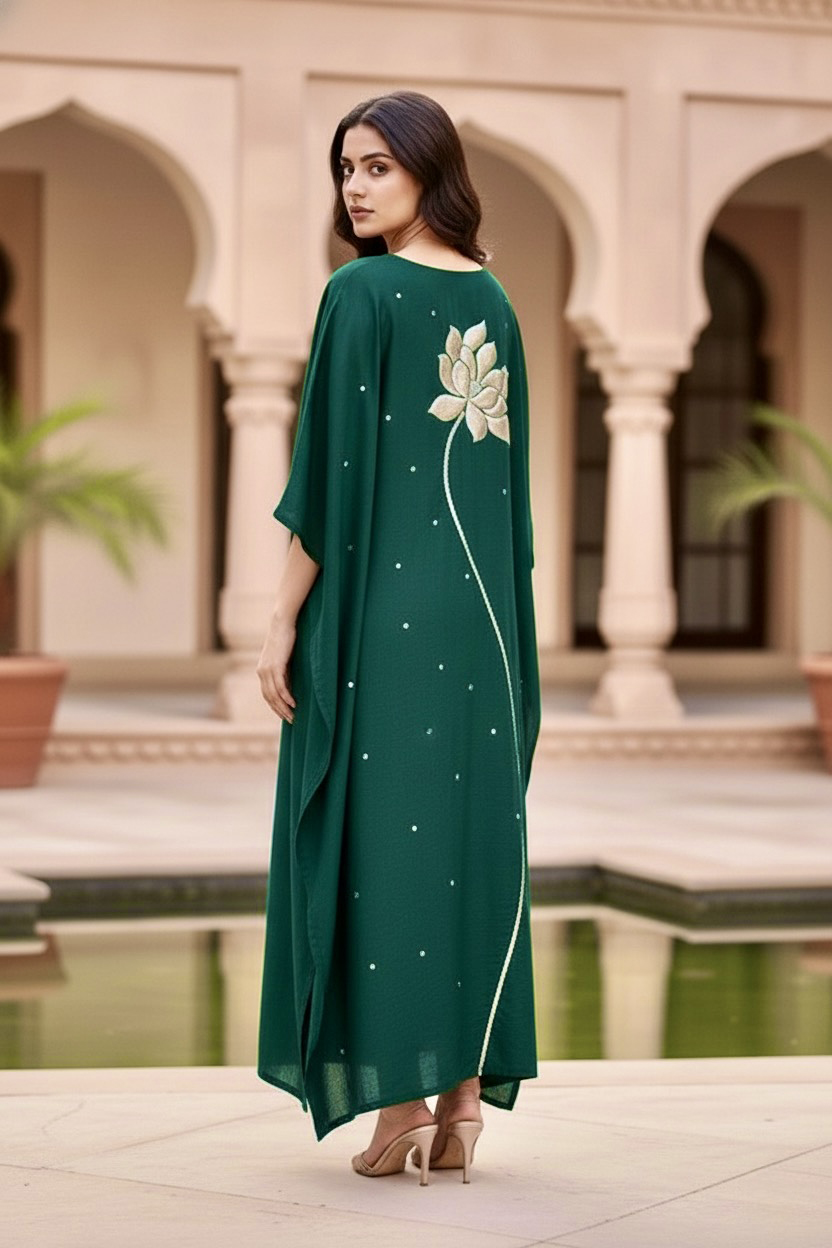 Woman wearing a green dress with floral embroidery in an outdoor setting. Product by Umaid Couture