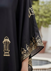 Black fabric with gold embroidery of architectural designs, held by a hand