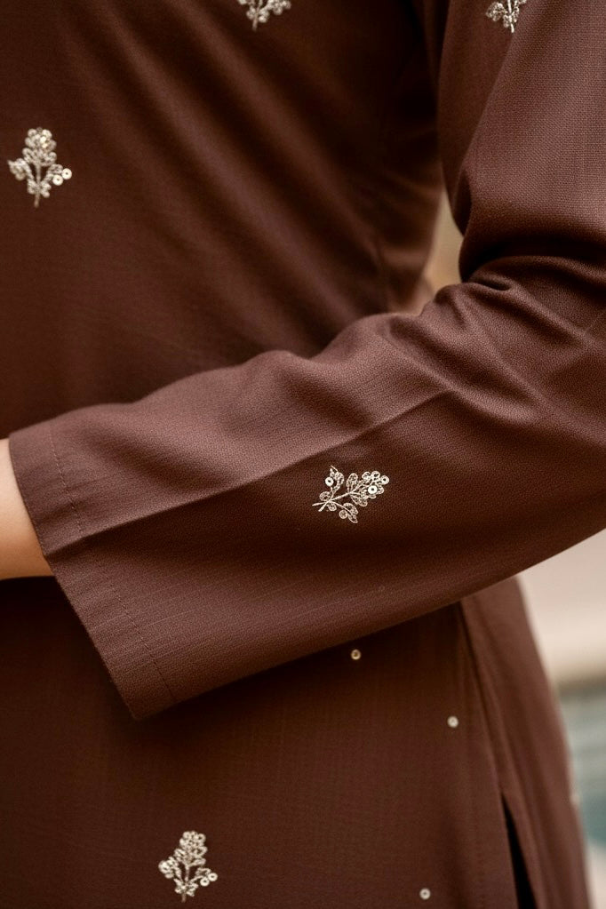 Brown garment with floral embroidery on a blurred background product by Umaid Couture