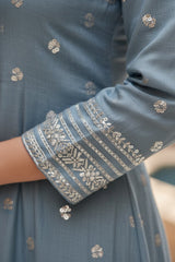 Close-up of a blue embroidered garment with intricate patterns.product by Umaid Couture.