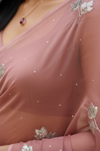Close-up of a off-bronze saree with silver leaf patterns and jewelry.