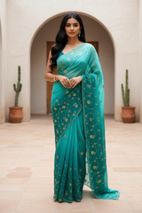 Woman wearing a teal saree by Umaid Couture with gold patterns in an indoor setting.