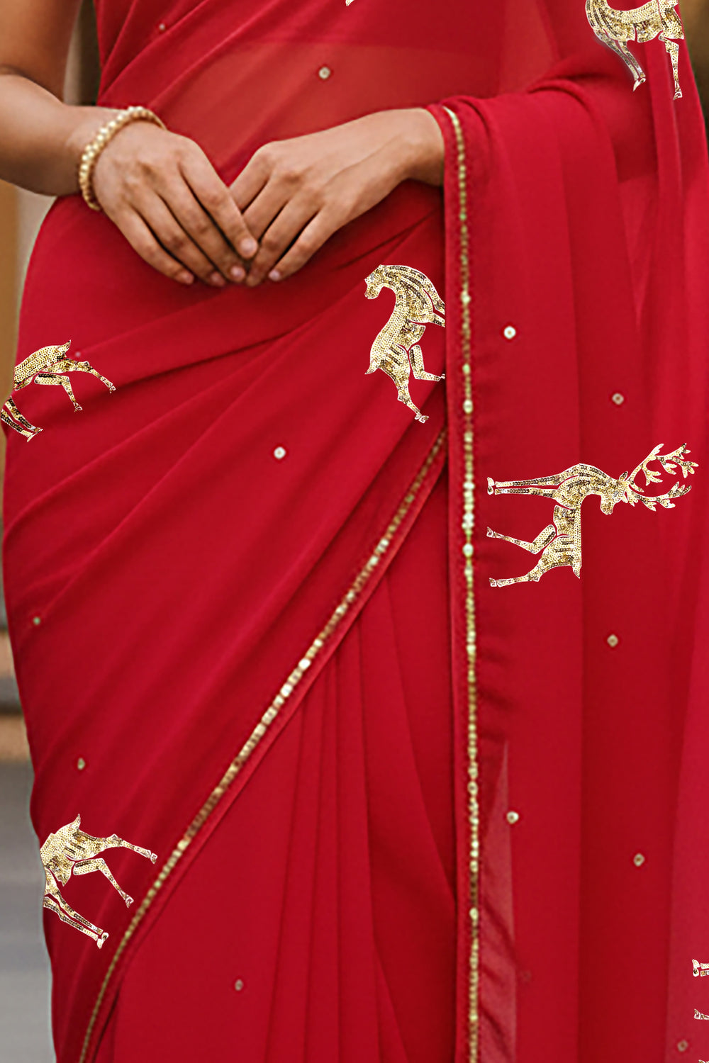 A woman in Red Caribou Golden Sequins Motif saree by Umaid Couture, standing in a Garden Courtyard