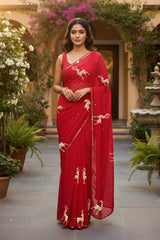 A woman in Red Caribou Golden Sequins Motif saree by Umaid Couture, standing in a Garden Courtyard