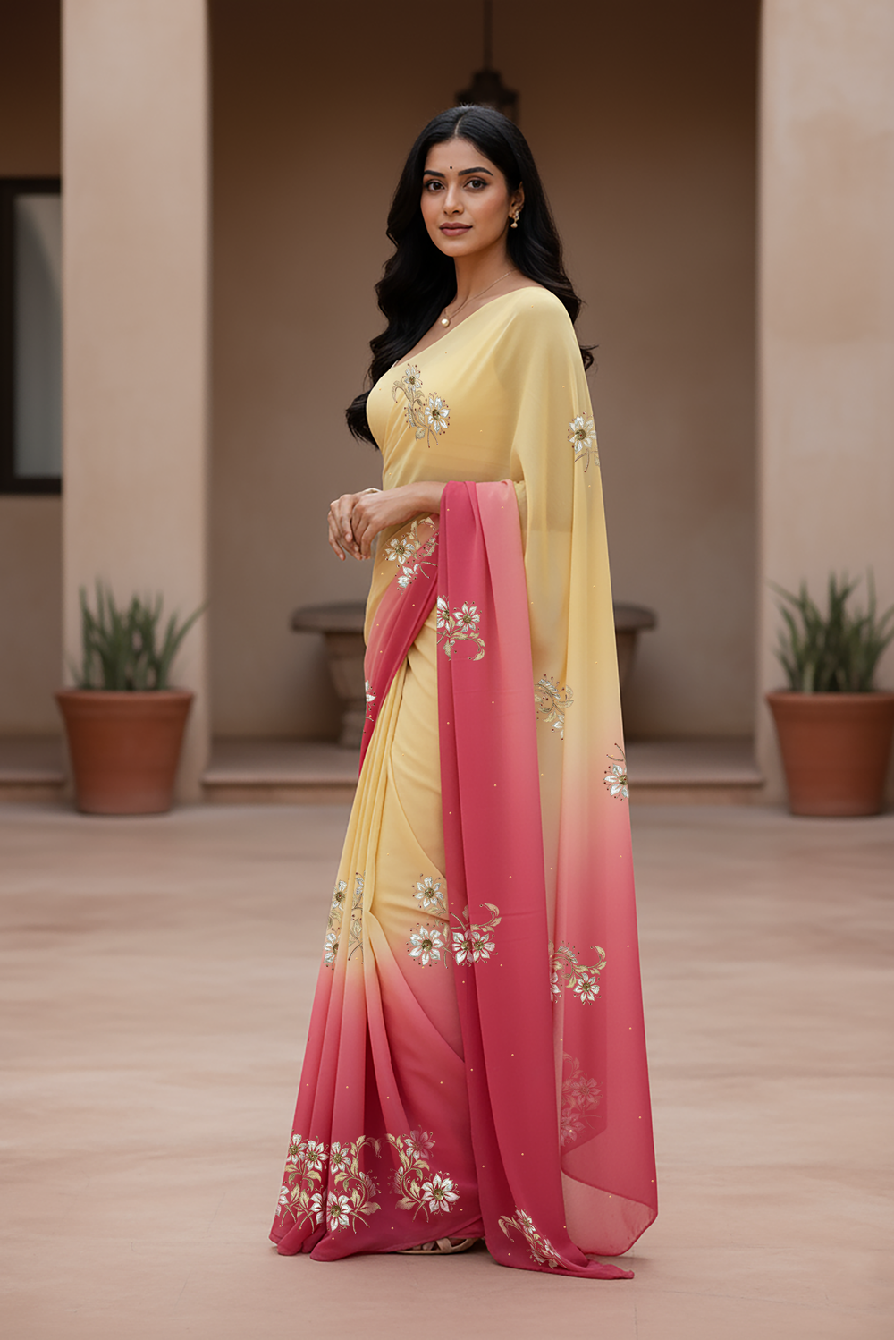 Woman wearing a yellow and pink saree  by Umaid Couture with floral patterns indoors.