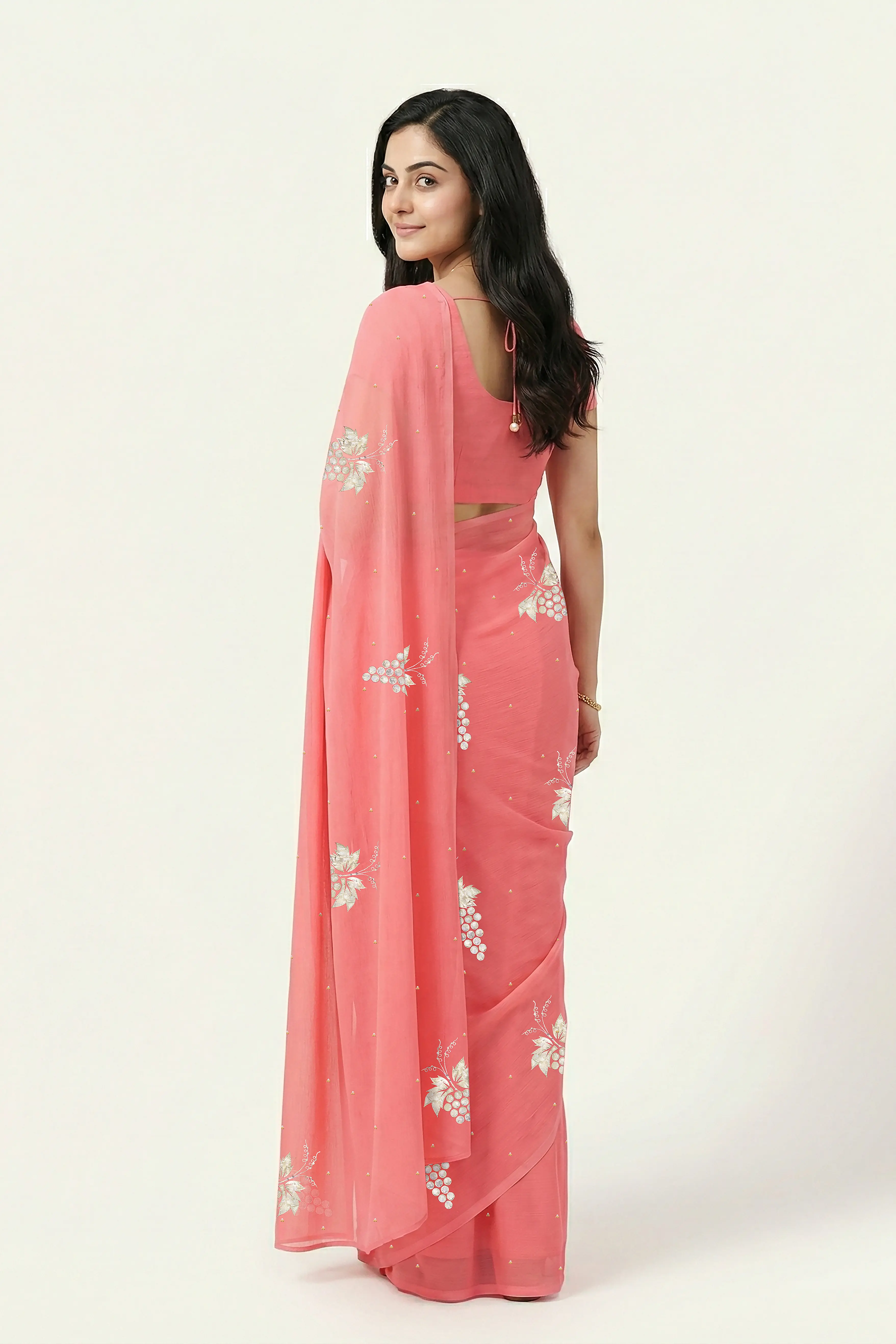 An Indian Woman in rose coral pink saree embellished with grape Motifs made of Gota, Zari and Sequins by Umaid Couture