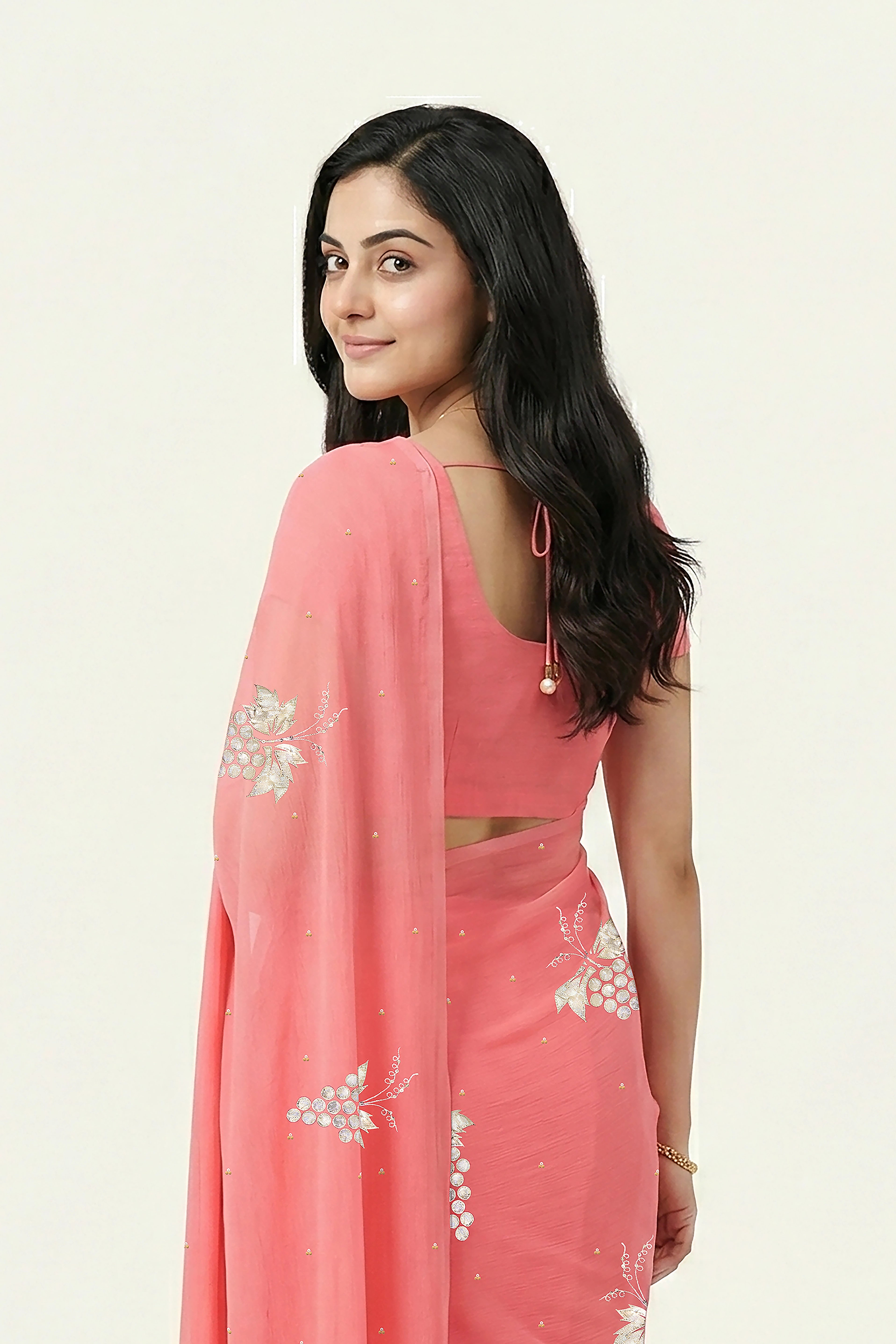 An Indian Woman in rose coral pink saree embellished with grape Motifs made of Gota, Zari and Sequins by Umaid Couture