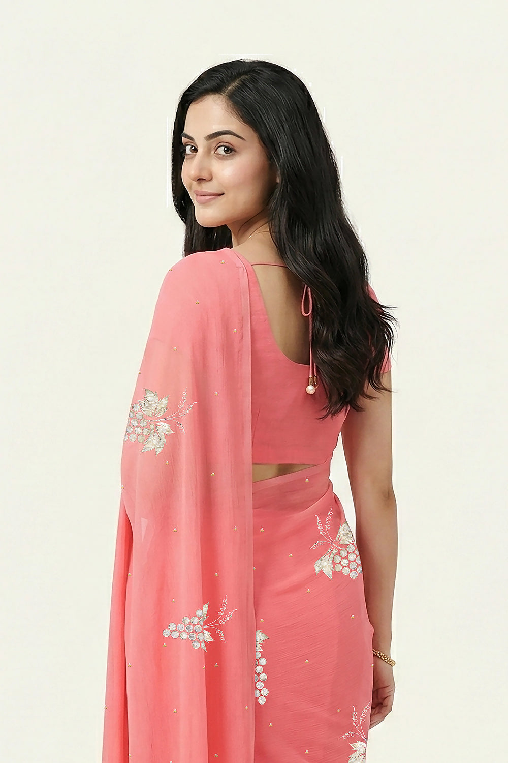 An Indian Woman in rose coral pink saree embellished with grape Motifs made of Gota, Zari and Sequins by Umaid Couture