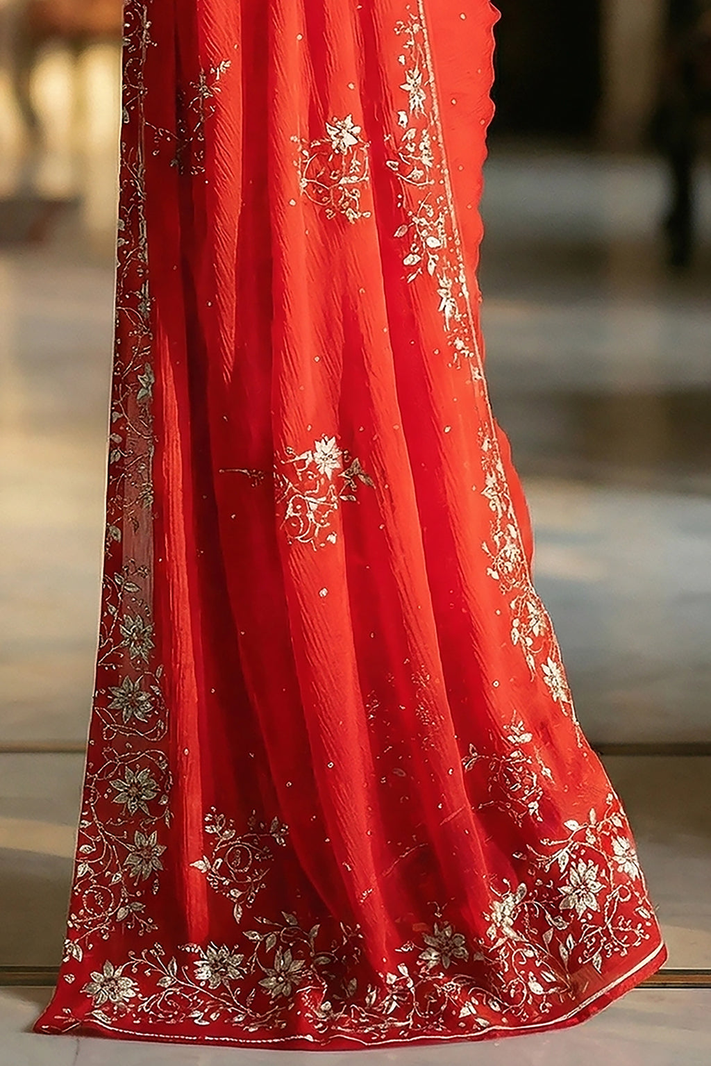 Woman in mulberry red saree with jasmine floral vines border on saree made by umaid couture.