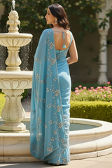 Model wearing Pearl Whispers Saree by Umaid Couture in shade of Blue standing in a garden Courtyard