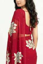 An Indian woman in Red Padma Saree embellished  with Blooming lotus flowers made of Gota, Zari & sequins by craft of Aari-Zardosi, a product of Umaid Couture