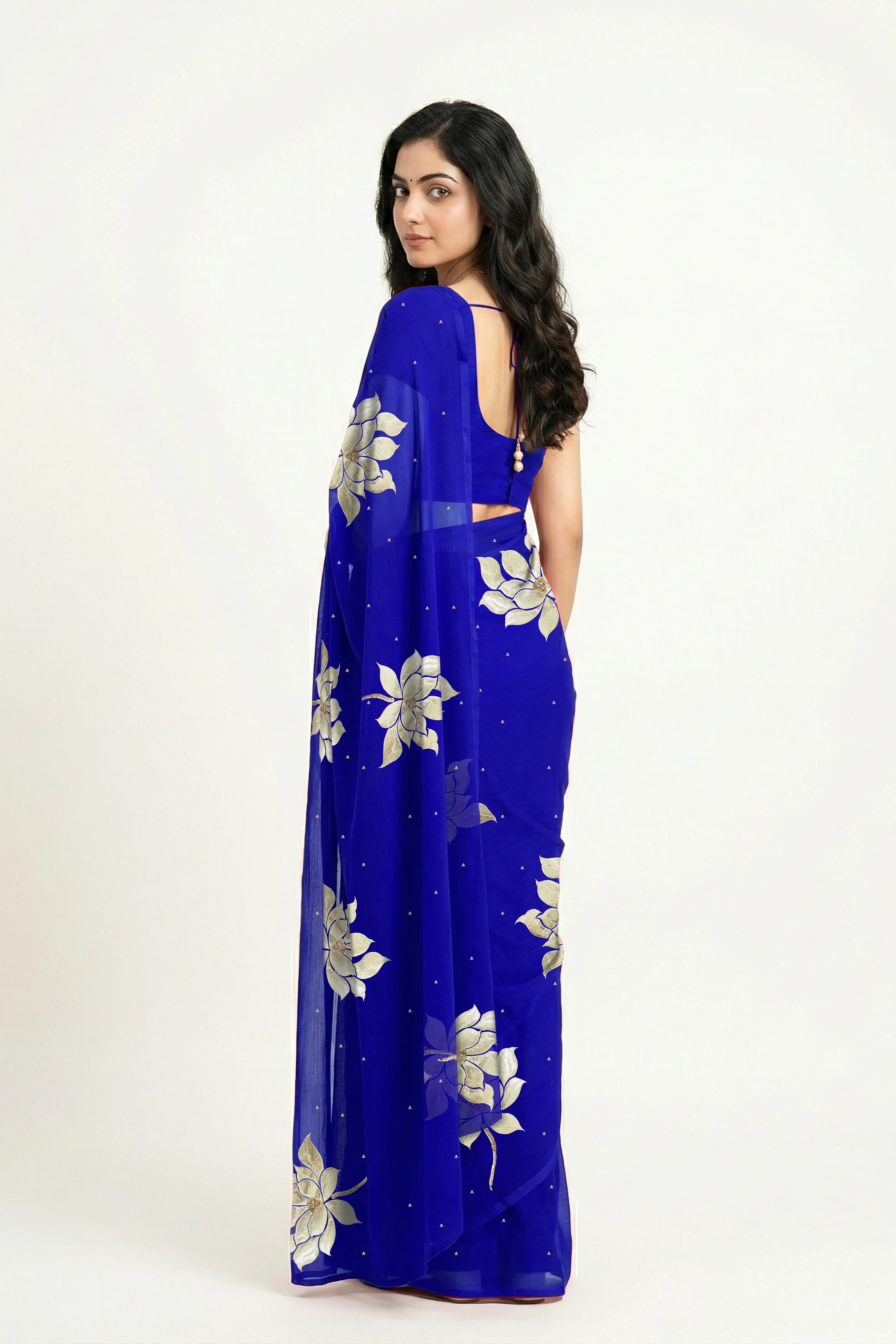 An Indian woman in blue Padma Saree embellished  with Blooming lotus flowers made of Gota, Zari & sequins by craft of Aari-Zardosi, a product of Umaid Couture