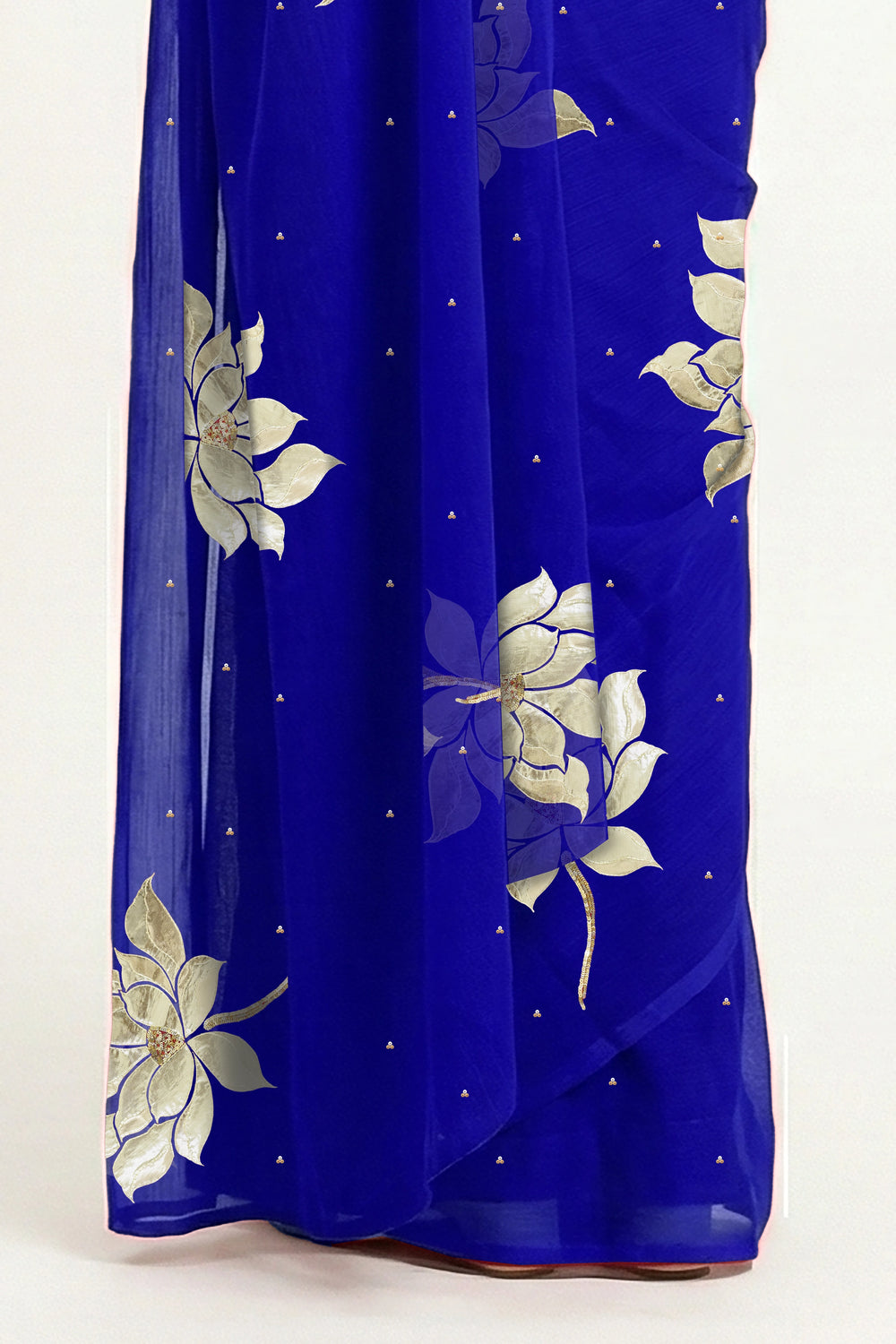 An Indian woman in blue Padma Saree embellished  with Blooming lotus flowers made of Gota, Zari & sequins by craft of Aari-Zardosi, a product of Umaid Couture