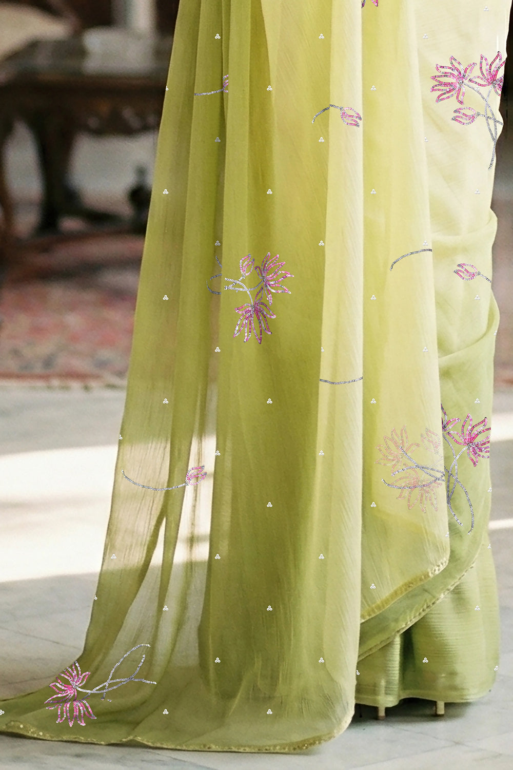 woman in green gradient saree with beautiful lotus motif made with pink and silver sequins and finely done with aari-zardosi made by umaid couture.