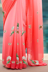 An Indian woman standing in a garden courtyard wearing a gradient of pink chiffon saree embellished with green and sliver sequin of l parrot siting in heritage style window motifs by Umaid Couture.  
