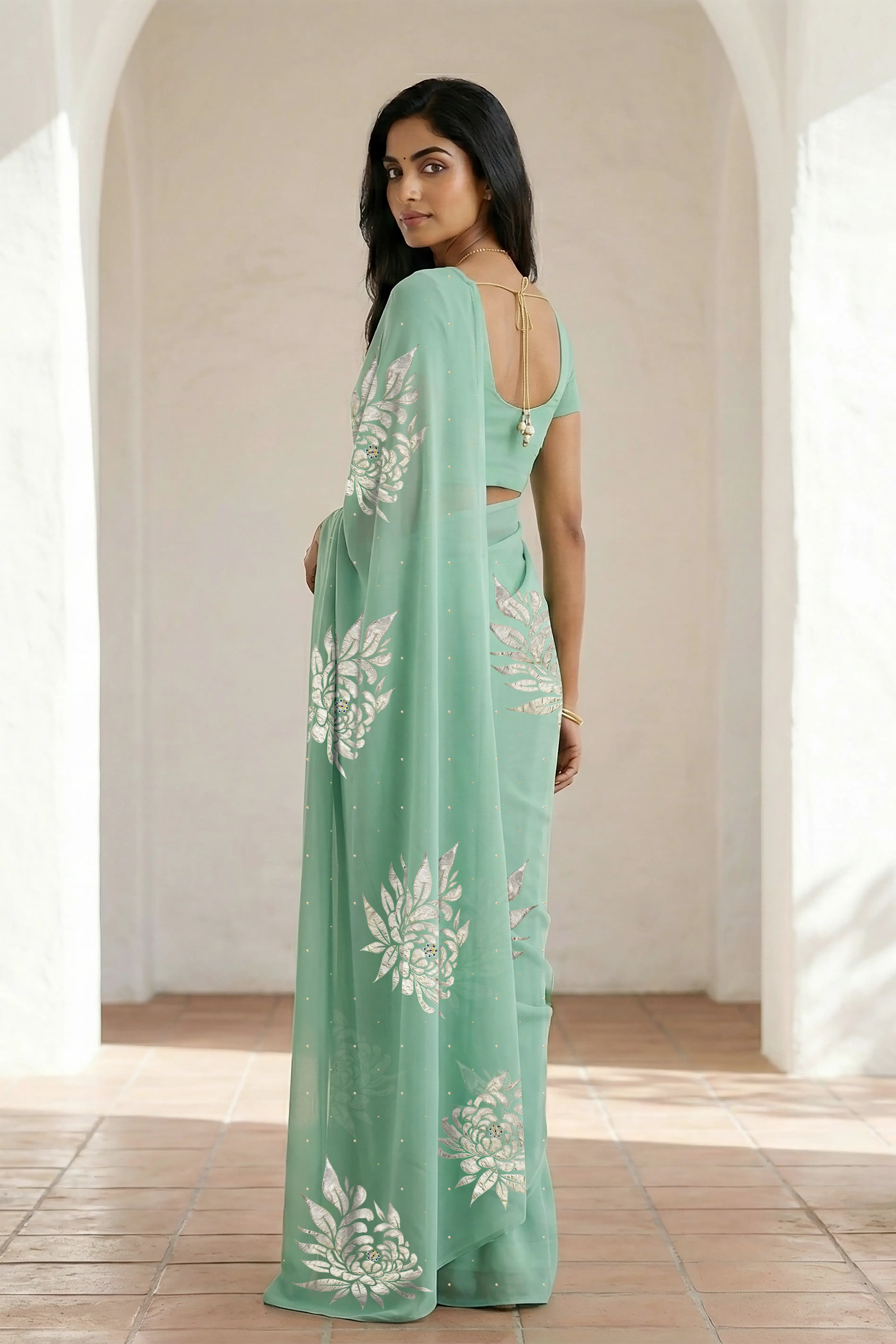 Woman wearing a light green saree with beautiful magnolia flower motif on it made by umaid couture.