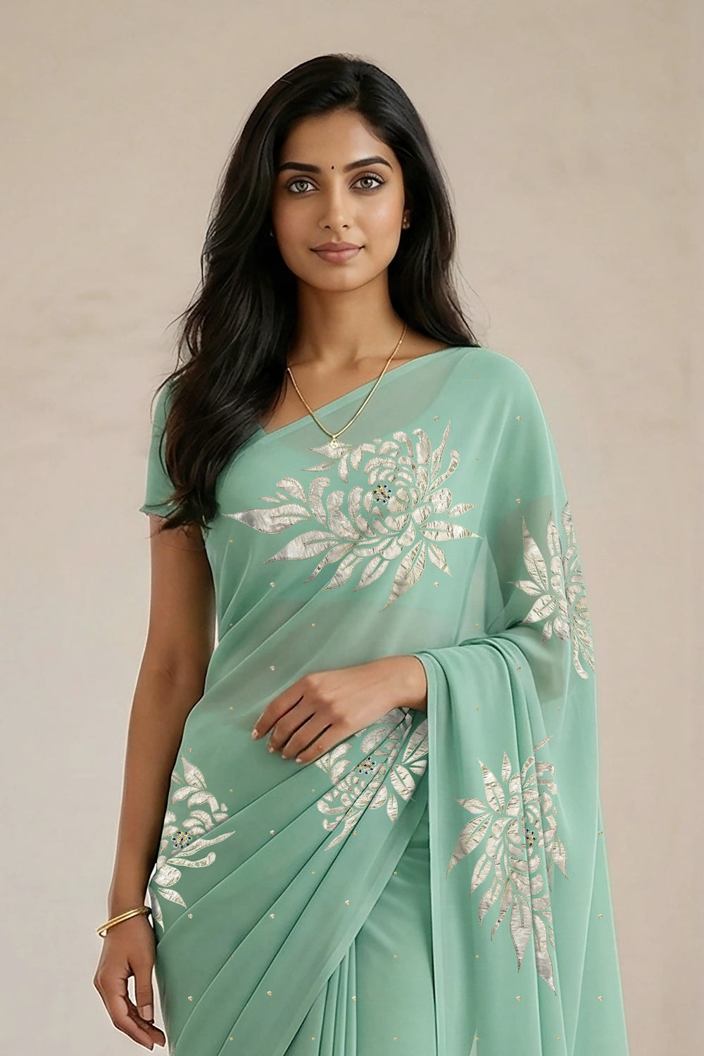Woman wearing a light green saree with beautiful magnolia flower motif on it made by umaid couture.