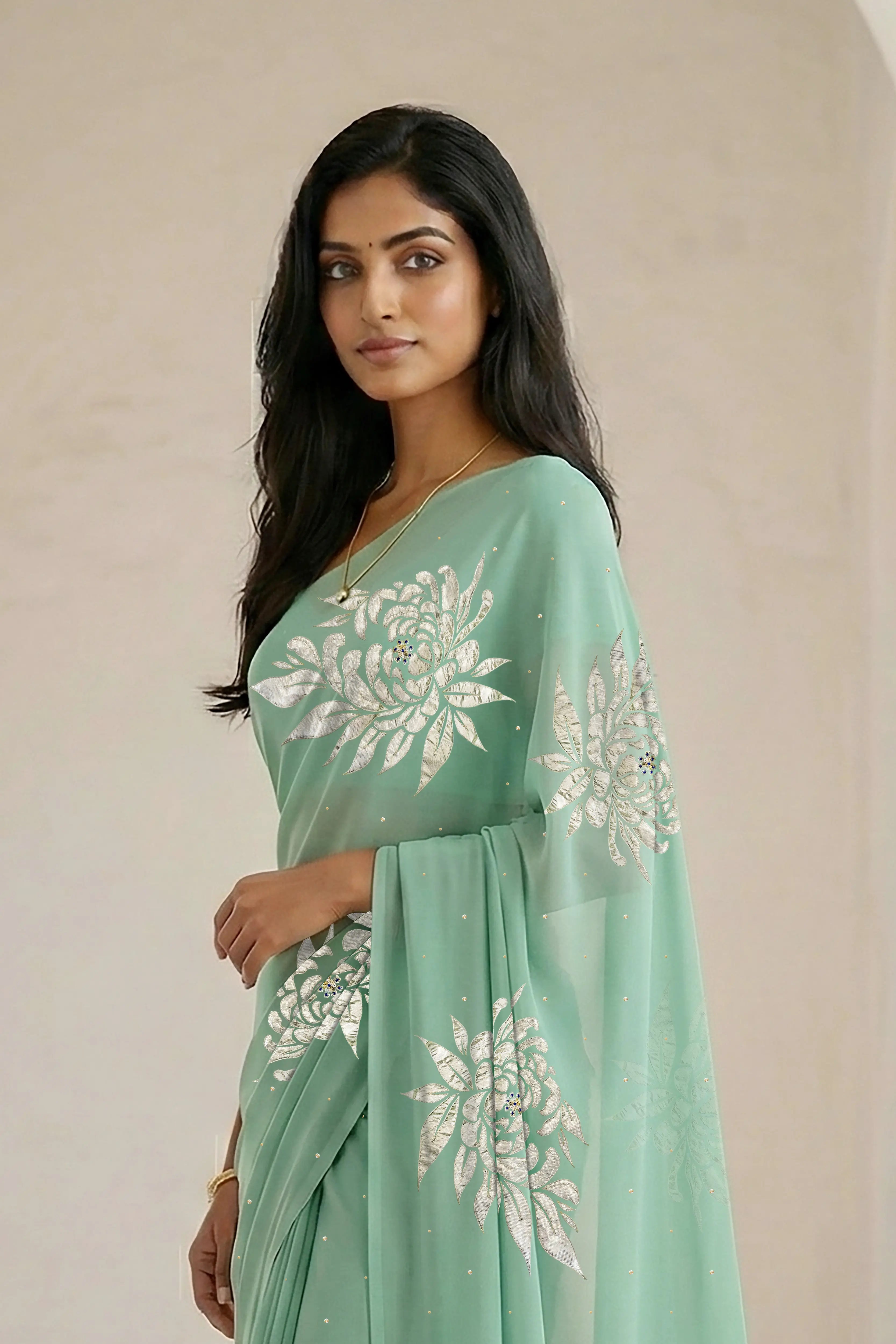 Woman wearing a light green saree with beautiful magnolia flower motif on it made by umaid couture.