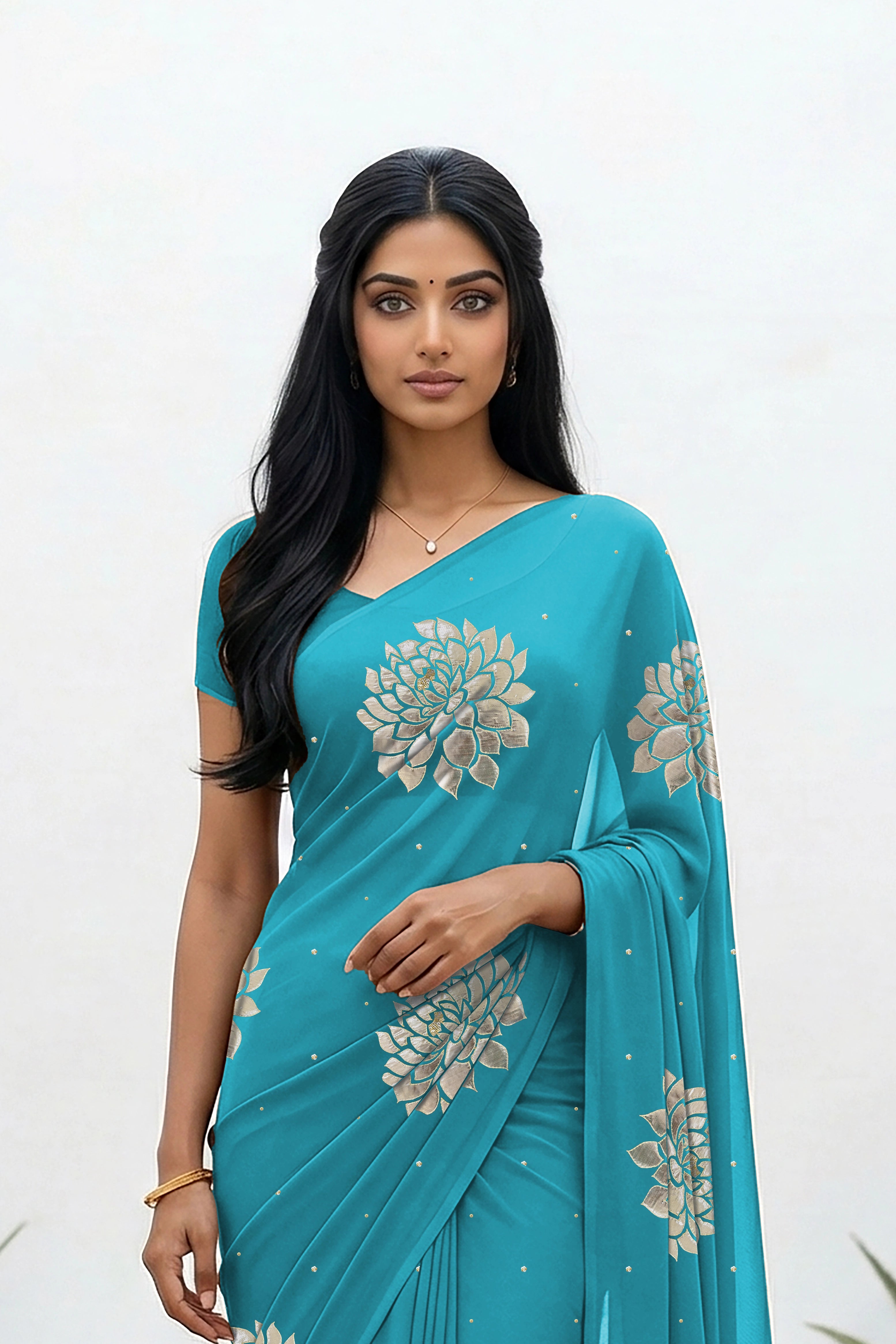 An Indian woman standing in a minimal white courtyard wearing a middle blue chiffon saree embellished with golden and sliver sequin of Dahlia flower motifs by Umaid Couture.  
