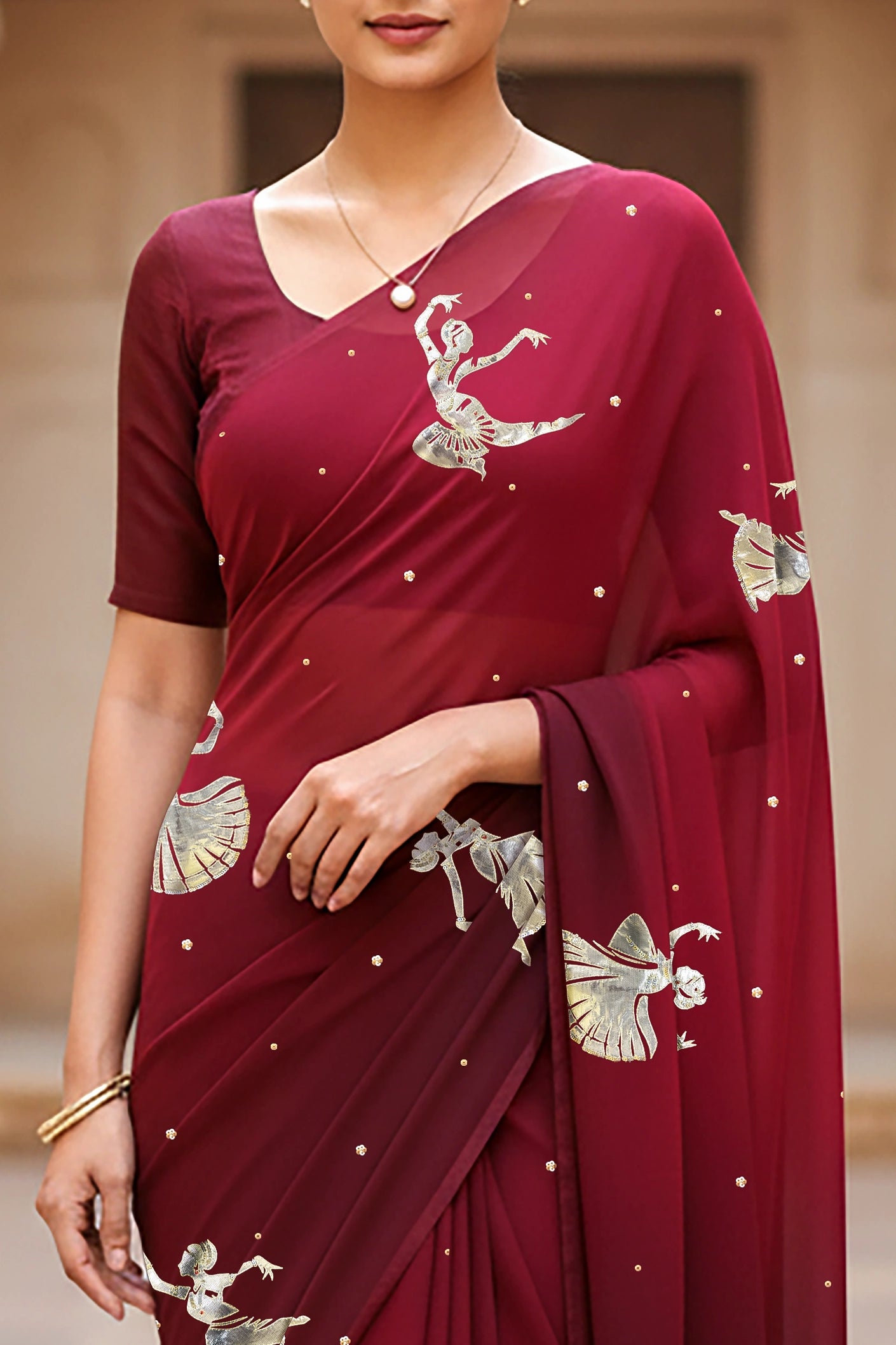 woman standing wearing wine red hue mulberry chiffon silk saree with kathak dance motifs on it designed bt umaid couture.