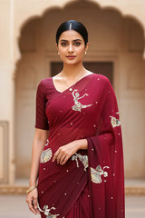 woman standing wearing wine red hue mulberry chiffon silk saree with kathak dance motifs on it designed bt umaid couture.