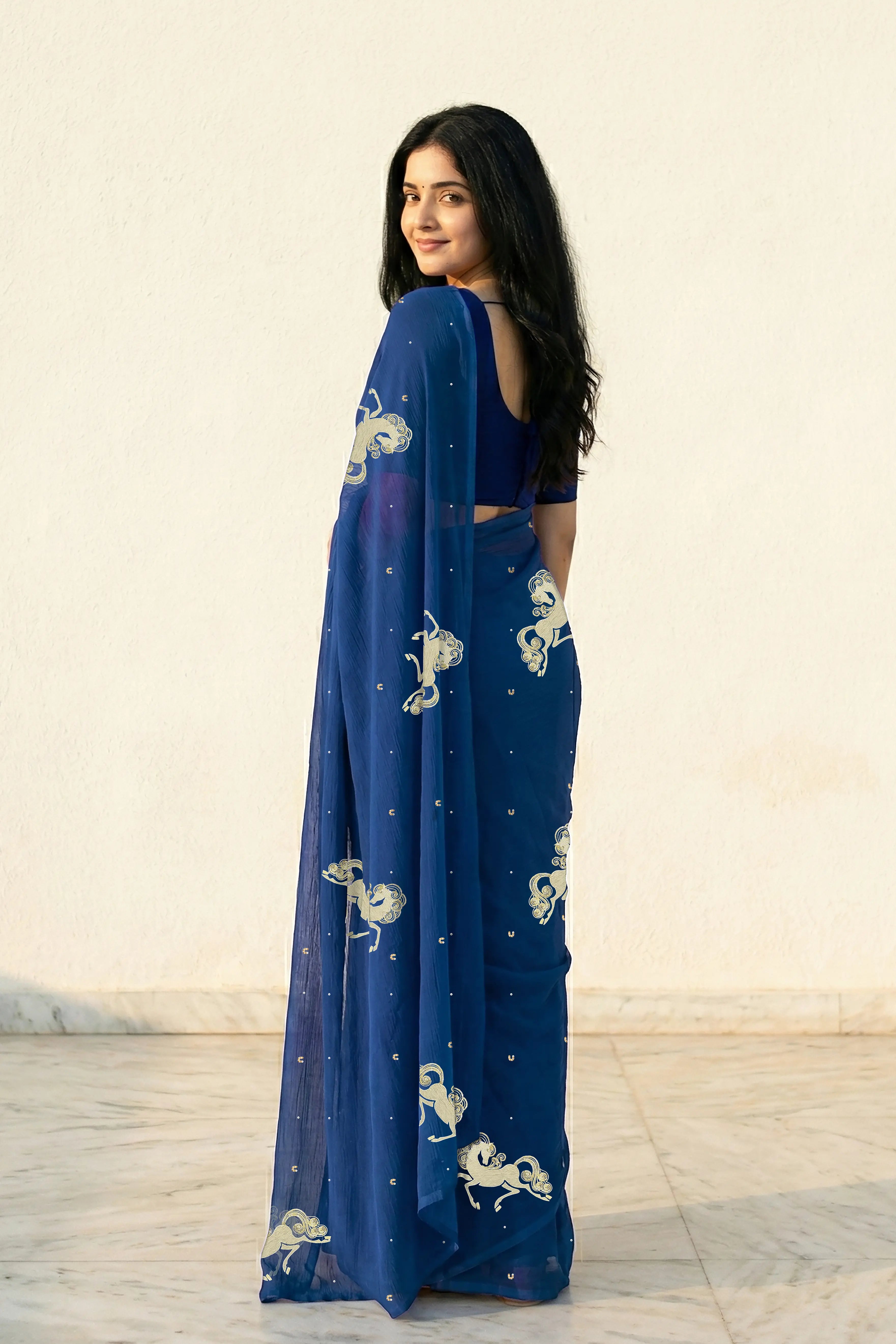 woman in Blue saree with silver golden sequins unicorn motif designs saree and finely work done with aari-zardosi  made by umaid couture.
