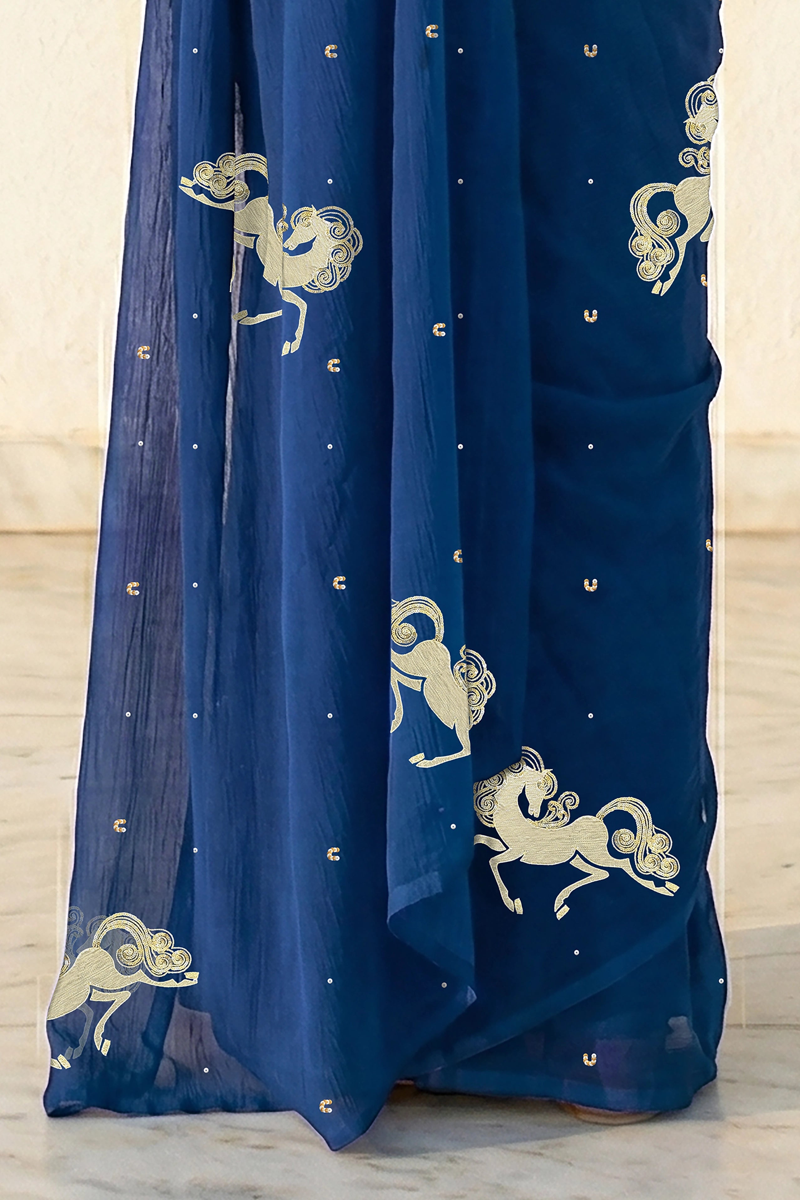 woman in Blue saree with silver golden sequins unicorn motif designs saree and finely work done with aari-zardosi  made by umaid couture.
