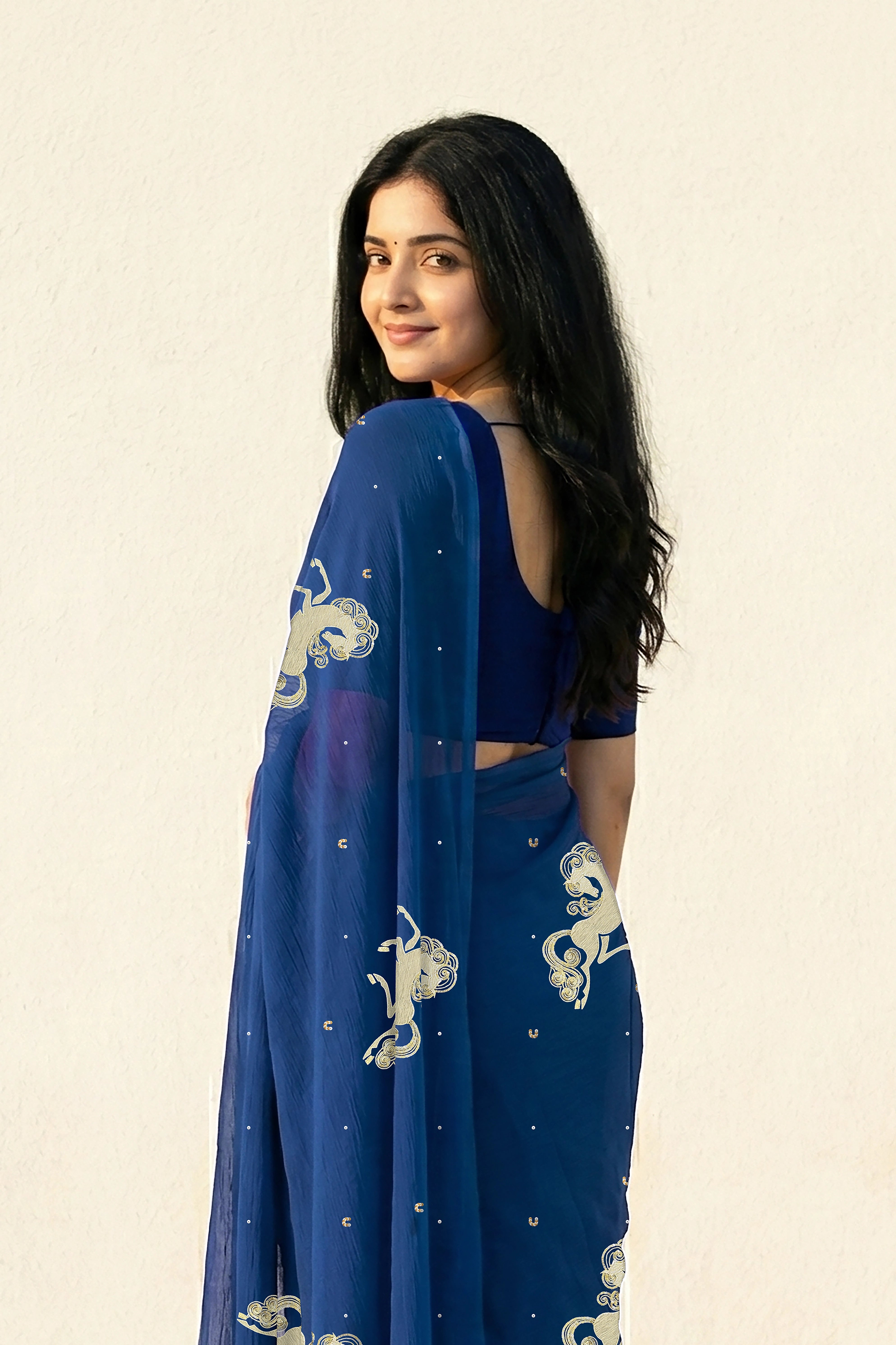 woman in Blue saree with silver golden sequins unicorn motif designs saree and finely work done with aari-zardosi  made by umaid couture.
