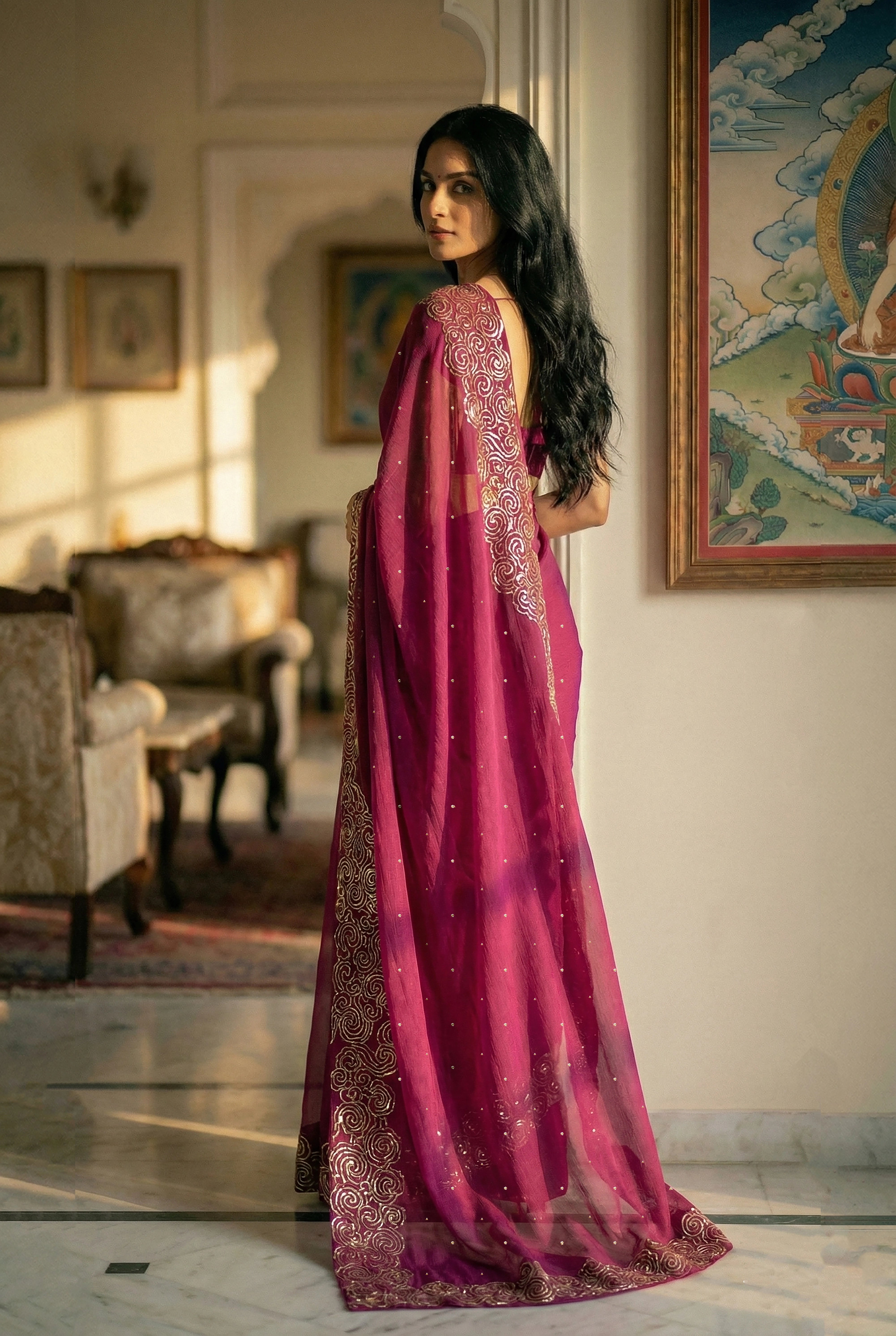 Woman in mulberry red saree with artistic cloud vines border on saree made by umaid couture.