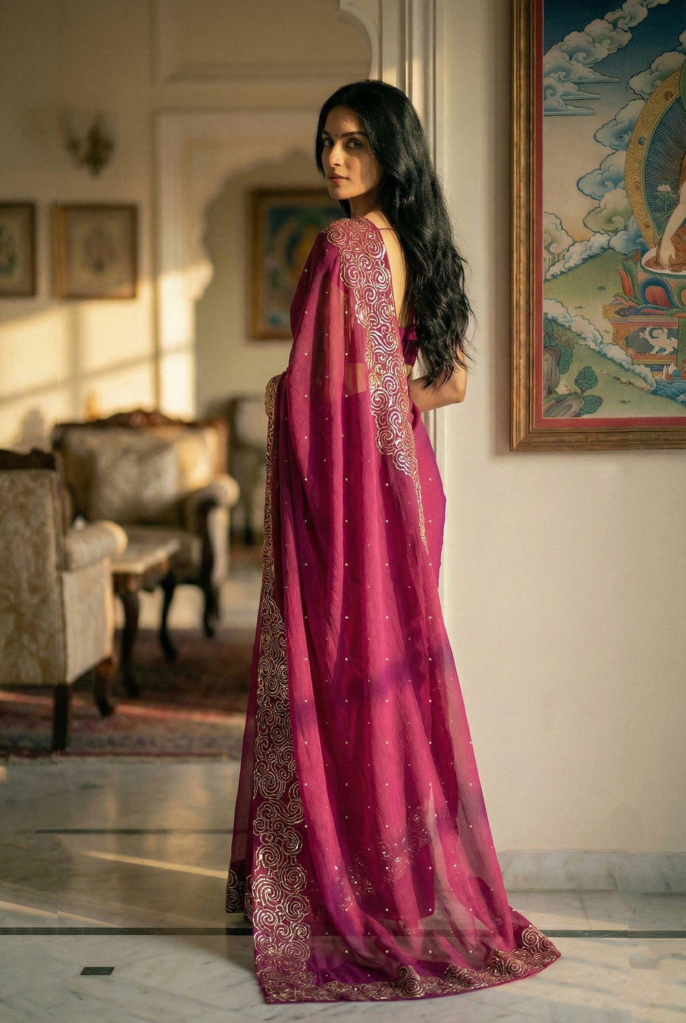 Woman in mulberry red saree with artistic cloud vines border on saree made by umaid couture.
