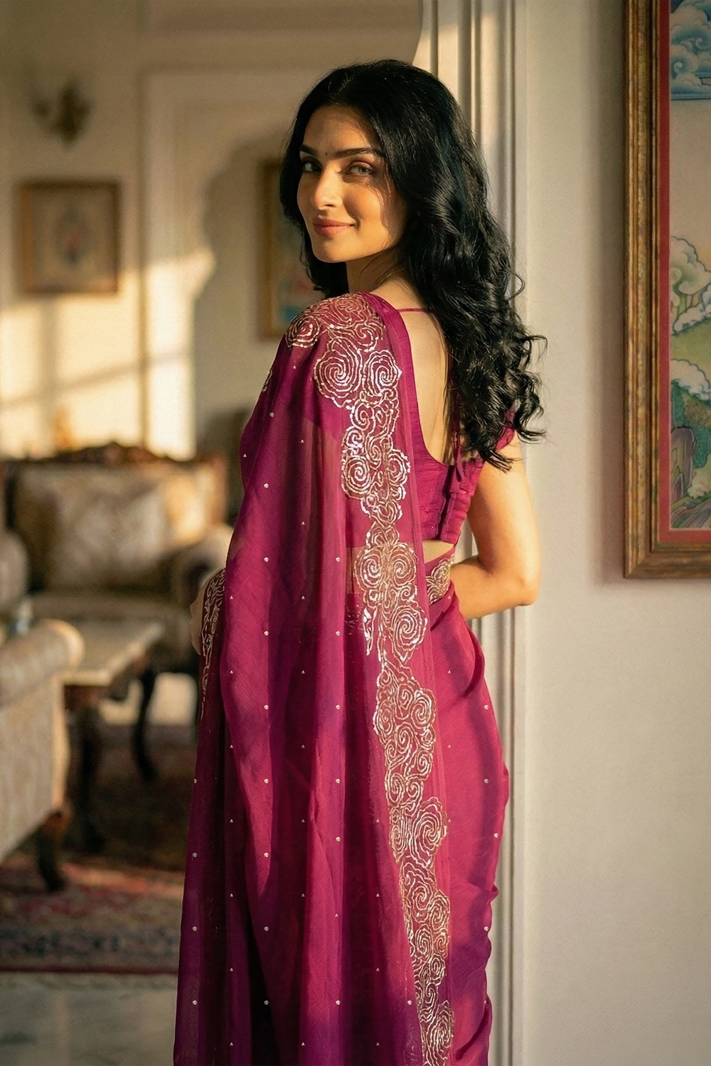 Woman in mulberry red saree with artistic cloud vines border on saree made by umaid couture.